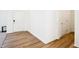 Hallway featuring wood-look flooring, white trim, and doors leading to various rooms at 430 Louisiana Dr, Pittsboro, IN 46167