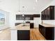 Modern kitchen with stainless steel appliances, dark cabinets and wood floors at 430 Louisiana Dr, Pittsboro, IN 46167