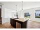 Kitchen island with stainless steel dishwasher, dark cabinets, and granite countertop at 430 Louisiana Dr, Pittsboro, IN 46167