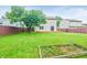 Expansive backyard featuring a well-maintained lawn, wooden fence, and garden bed, ideal for outdoor activities at 5541 Lippan Way, Indianapolis, IN 46221