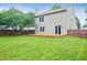 Spacious backyard with a lush green lawn, mature tree, and wooden deck, perfect for enjoying the outdoors at 5541 Lippan Way, Indianapolis, IN 46221