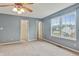 Bright bedroom with a ceiling fan, plush carpet, and a large window showcasing the outdoor view at 5541 Lippan Way, Indianapolis, IN 46221