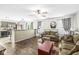 Open-concept living room with hardwood floors, ceiling fan, and seamless flow into the kitchen at 5865 Pennekamp Dr, Plainfield, IN 46168