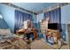 Cluttered bedroom with desk, TV, and window, bathed in blue tones at 6349 S Harding St, Indianapolis, IN 46217