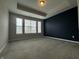 A bright bedroom features plush carpet, neutral walls, and an accent wall, complemented by natural light from the windows at 9215 Hawley Dr, Indianapolis, IN 46216