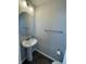 A stylish powder room with an oval mirror, pedestal sink, and modern fixtures create a functional and aesthetically pleasing space at 9215 Hawley Dr, Indianapolis, IN 46216