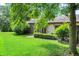 Landscaped backyard with grass, trees, bushes, siding, and brick, and a glimpse of the home at 9578 Cadbury Cir, Indianapolis, IN 46260