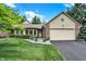 Charming brick home featuring an attached two-car garage, well-maintained lawn, and lush landscaping at 9578 Cadbury Cir, Indianapolis, IN 46260