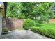 A stone patio surrounded by green plants, with a brick wall visible in the background at 9578 Cadbury Cir, Indianapolis, IN 46260