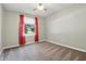 Cozy bedroom featuring a ceiling fan, a window with red curtains, and neutral walls and carpet at 1011 Stevedon Ct, Plainfield, IN 46168