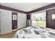 This cozy bedroom features purple walls, a large window with blinds, and double door closet at 10173 Stillwell Dr, Avon, IN 46123
