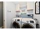 This laundry room features side-by-side Samsung washers and dryers, and above-the-washer storage at 10173 Stillwell Dr, Avon, IN 46123