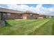 Large backyard features manicured lawn and brick exterior of home in a residential area at 114 Asbury Dr, Anderson, IN 46013
