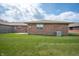 Spacious backyard features a well-maintained lawn and brick exterior of the home at 114 Asbury Dr, Anderson, IN 46013