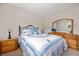 Cozy bedroom featuring a comfortable bed with a lovely quilt and matching wood furniture at 114 Asbury Dr, Anderson, IN 46013