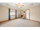 A roomy bedroom features a tray ceiling, fan, and a chair by the window at 114 Asbury Dr, Anderson, IN 46013