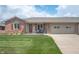 Charming single-story brick home featuring a well-maintained lawn and attached two-car garage at 114 Asbury Dr, Anderson, IN 46013