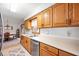 A bright kitchen shows ample wood cabinets, countertops, and stainless steel dishwasher at 114 Asbury Dr, Anderson, IN 46013