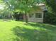 Lush backyard featuring mature trees, a well-maintained lawn, and a cozy sunroom addition at 1327 Goldfinch Dr, Carmel, IN 46032