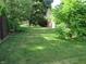 Spacious backyard with lush lawn, bordered by mature trees and partial fencing at 1327 Goldfinch Dr, Carmel, IN 46032