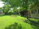 Spacious backyard with a well-kept lawn, garden boxes, and mature trees providing shade at 1327 Goldfinch Dr, Carmel, IN 46032