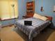 Bedroom showcasing a blue bedspread, a floor lamp, and a wooden bookshelf at 1327 Goldfinch Dr, Carmel, IN 46032