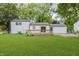A lush green backyard with a view of a white home with a wooden deck at 1537 Mutz Dr, Indianapolis, IN 46229