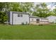 An expansive backyard features a white house with a chimney and a small wooden deck at 1537 Mutz Dr, Indianapolis, IN 46229