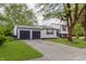 View of the home and attached two-car garage, showcasing the lawn and driveway at 1537 Mutz Dr, Indianapolis, IN 46229