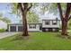 Charming split-level home featuring a well-manicured lawn, two-car garage, and mature trees at 1537 Mutz Dr, Indianapolis, IN 46229