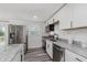 Updated kitchen featuring stainless steel appliances, stone countertops, and new vinyl flooring at 1537 Mutz Dr, Indianapolis, IN 46229