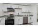 Updated kitchen with stainless steel appliances, granite countertops, and modern white cabinets at 1537 Mutz Dr, Indianapolis, IN 46229