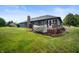 Spacious backyard featuring well-maintained grass, a wooden deck, and the rear of the home at 180 Wellington Pkwy, Noblesville, IN 46060