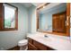 Updated bathroom with wooden vanity, white sink, toilet, and a window for natural light at 180 Wellington Pkwy, Noblesville, IN 46060