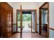 Inviting foyer featuring a half glass front door, wood floors and trim, and coat closet at 180 Wellington Pkwy, Noblesville, IN 46060