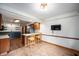 Open kitchenette with wood cabinets, stainless fridge and two-seat breakfast bar, perfect for dining at 180 Wellington Pkwy, Noblesville, IN 46060
