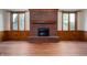 Cozy living room with brick fireplace, wood-look floors, and large windows at 180 Wellington Pkwy, Noblesville, IN 46060