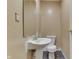 Functional half bathroom featuring a pedestal sink, toilet, and minimalist design at 1924 W 65Th Pl, Indianapolis, IN 46260