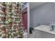 Charming bathroom with shower-tub combo, privacy curtain, modern sink, and gray walls at 1924 W 65Th Pl, Indianapolis, IN 46260