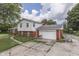 Two-story home featuring a brick garage, partial brick facade, and concrete driveway at 1924 W 65Th Pl, Indianapolis, IN 46260
