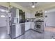 Kitchen with stainless steel appliances, white cabinetry, tile floors, and access to other rooms at 1924 W 65Th Pl, Indianapolis, IN 46260