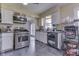 View of the kitchen with stainless steel appliances, white cabinetry and tiled flooring at 1924 W 65Th Pl, Indianapolis, IN 46260
