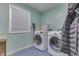 Efficient laundry area with side-by-side washer and dryer, plus a window and shelving at 1924 W 65Th Pl, Indianapolis, IN 46260