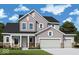 Charming two-story home with stone accents, a three-car garage and manicured lawn at 19796 Chatham Shore Ln, Westfield, IN 46074