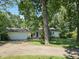 Charming home featuring an attached garage and welcoming blue front door surrounded by mature trees at 2024 E 41St St, Anderson, IN 46013