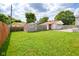 Spacious backyard featuring a well-maintained lawn, partial fence, and shed with the property's garage at 2520 Tesh Dr, Indianapolis, IN 46203