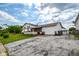 Side view of a white home featuring a red roof, front porch, attached garage, and a spacious driveway at 2520 Tesh Dr, Indianapolis, IN 46203