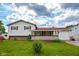 Charming two-story home with a red roof, white siding, covered front porch, and a lush front lawn on a sunny day at 2520 Tesh Dr, Indianapolis, IN 46203