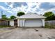 View of a detached two car garage and door, side entrance and partial surrounding fence at 2520 Tesh Dr, Indianapolis, IN 46203
