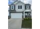 Charming two-story home features a gray and white exterior, attached two-car garage, and welcoming entrance at 269 Switchgrass Ln, New Whiteland, IN 46184